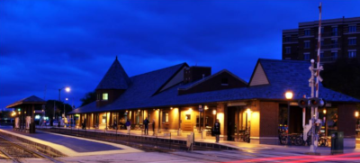 A train station just after dark, with clouds behind and its outdoor lights on in Arlington Heights Illinois