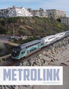 Metrolink brochure cover showing a train on tracks along a beach with multi story buildings behind on top of a hill.