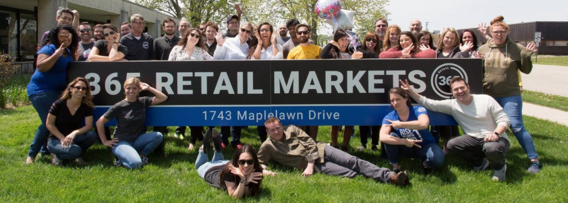 365 Retail Markets team photo by their sign.