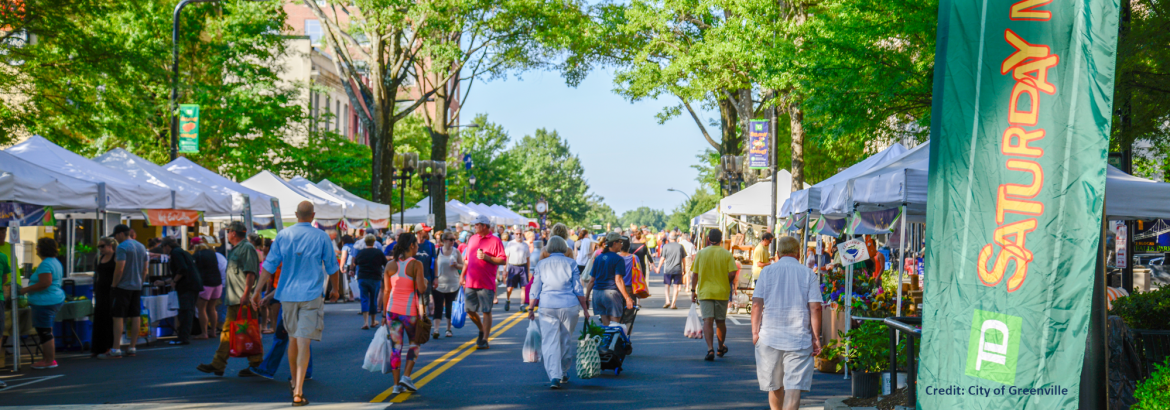 Municipal Association of South Carolina; A view of the City of Greenville's Saturday Market on a street lined with vendor tents.