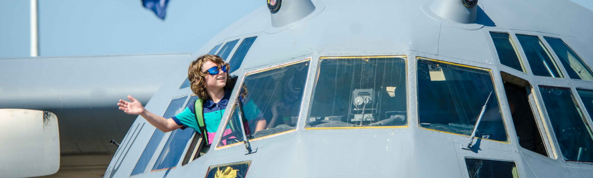 Rosecrans memorial airport military plane with a young child leaning out a front window and waving.