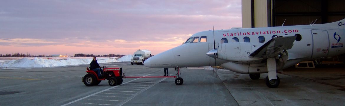 Yarmouth International Airport tractor pulling a plane out of a hangar.