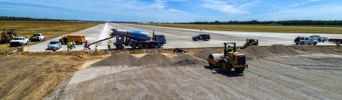Oscoda-Wurtsmith Airport OWA runway construction with work vehicles and people present